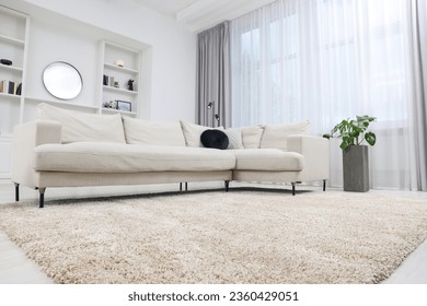 Fluffy carpet and stylish furniture on floor indoors - Shutterstock ID 2360429051