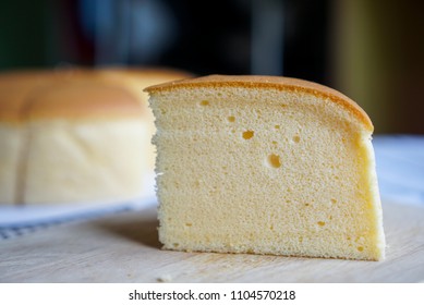 Fluffy cheese cake, a pieces of sponge cake with soft texture. On wooden plate.
