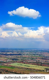 Fluffy Cloud on Clear Blue Sky with landscape below 