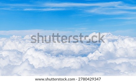 Fluffy clouds cover the sky while bright blue stretches above. The scene represents a typical afternoon sky with clouds.