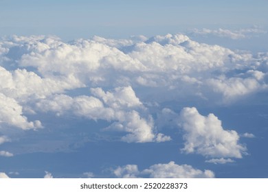 Fluffy clouds (cumulus, stratocumulus) with blue sky view from airplane - Powered by Shutterstock