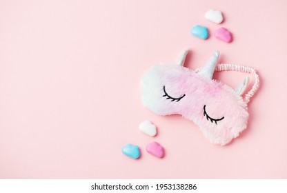 Fluffy fur sleep eye mask unicorn on pink paper background, copy space. Top view, flat lay. Concept relaxation and sweet dreams - Powered by Shutterstock