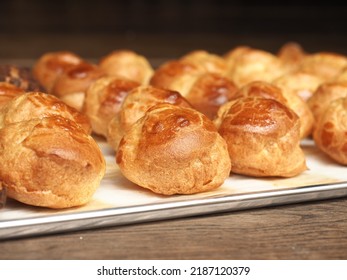 fluffy golden brown baked choux pastry on baking tray