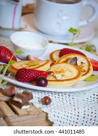 Fluffy pancakes from cottage cheese  with fresh berries, tea and syrup. Fresh pancakes with fruits. Pancakes from cottage cheese with berries, a light background, breakfast,top view. 