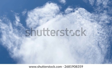 Fluffy white clouds against a clear blue sky.