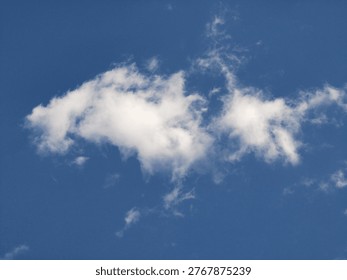 Fluffy white clouds float in a bright blue sky, indicating a clear day with vibrant sunlight and minimal atmospheric disturbances