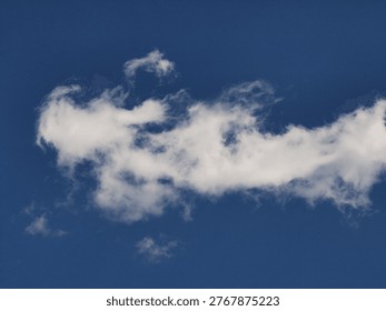 Fluffy white clouds float in a clear blue sky, providing a peaceful and unobstructed view of the atmosphere above