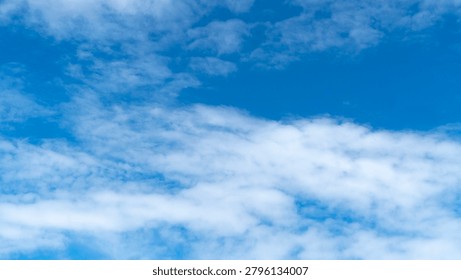 Fluffy white clouds float motionless in the bright blue sky.