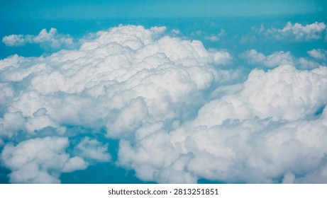 Fluffy white clouds float in a serene blue sky, creating a tranquil and airy atmosphere.