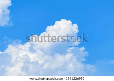 Fluffy white cumulus clouds float against a vibrant blue sky, creating a serene and calming atmosphere. The focus is on the cloud formations.