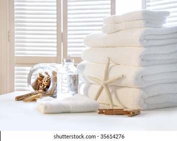 Fluffy White Towels On Table With Shutter Doors