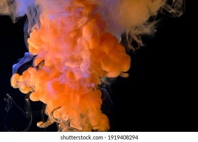 Fluid art. Abstract background from liquid paints. Orange flow on black.