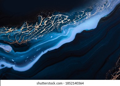 Fluid Art. Liquid Metallic Gold in abstract blue wave. Marble effect background or texture.
