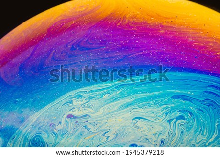 Fluid art made of colorful soap bubble film. Trendy Inkscape blurred background. Alien space planets art. Selective focus.