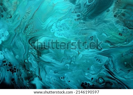 Fluid Art. Turquoise and blue abstract waves with golden particles on black background. Marble effect background or texture