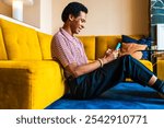 Fluid gender young man wearing cross dressing clothing at home, LGBTQ and diversity concepts - Hispanic non binary male portrait in a colorful apartment, LGBT people concepts