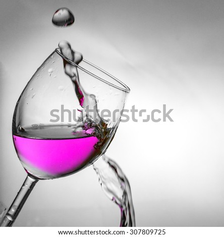 Fluid motion of coloured water in a wine glass.