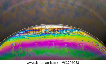 Fluid soap bubble looking like planets. Psychedelic colorful abstract art with urreal patterns of color in motion.