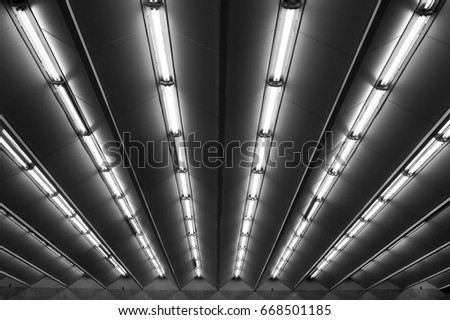 Fluorescent lamps line, view of metro station ceiling