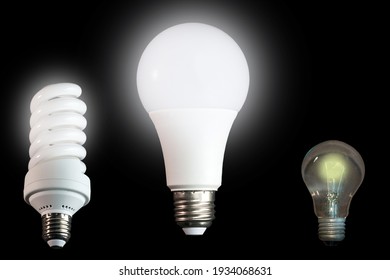 Fluorescent spiral bulb, LED bulb and incandescent lamp on a black background.