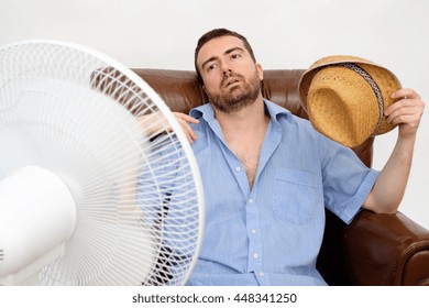Flushed man feeling hot in front of a fan 