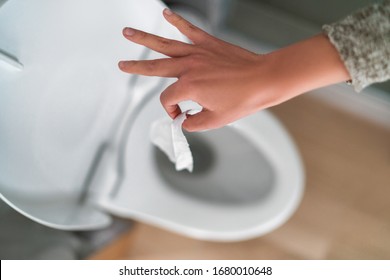 Flushing down disinfectant wipes as toilet paper shortage alternative during panic buying coronavirus outbreark causing home toilets to clog. - Shutterstock ID 1680010648