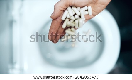 Flushing medical capsules into the toilet. Bad drug concept Foto stock © 