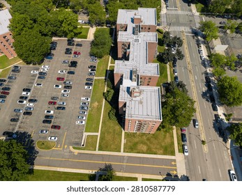 Flushing queens ny arial view showing multiple residential apartment buildings with their flat roofs. A sprawling parking lot filled with cars. A busy city street