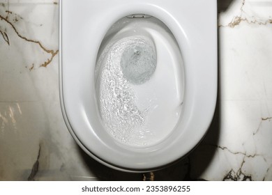 Flushing toilets. Close up flushing water in toilet bowl. Toilet, flushing water. Selective focus. Top view - Powered by Shutterstock