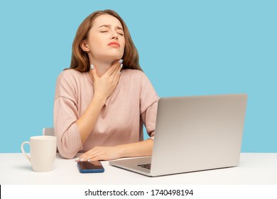 Flu-sick young woman employee sitting at workplace with laptop and holding painful neck, suffering sore throat, inflamed tonsils, influenza symptoms. indoor studio shot isolated on blue background - Powered by Shutterstock