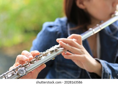 Flute Classical Instrument Player Playing Song. Instructor Practicing Bronze Woodwind For Orchestra As Solo With Green Bokeh Outside With Nature.