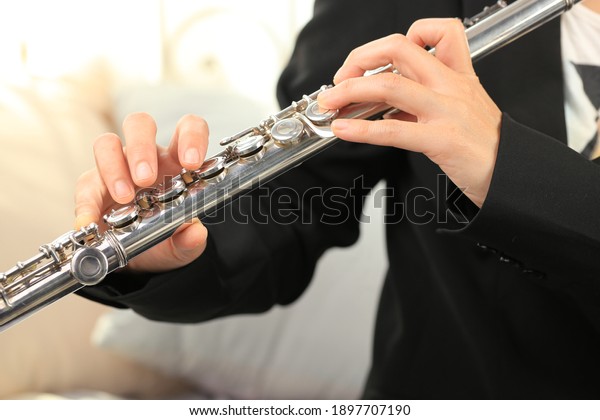 Flute\
classical instrument profestional player playing song. Instructor\
practicing bronze woodwind for orchestra as\
solo.