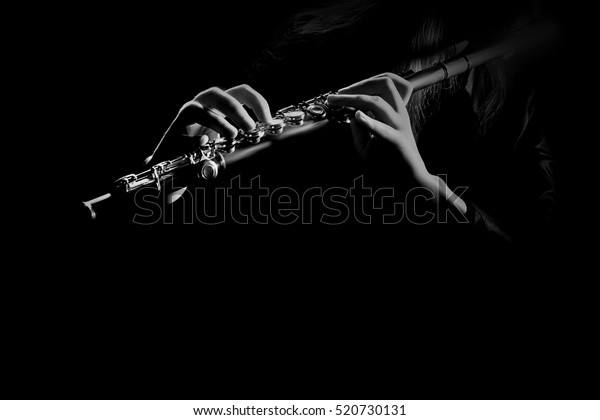 Flute instrument closeup Flutist hands\
playing flute music isolated on black\
background