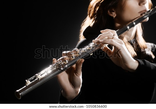 Flute instrument. Flutist hands playing\
flute music instrument. Closeup of flute\
player