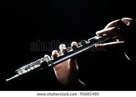 Flute music instrument details playing. Hand of flutist musician on black