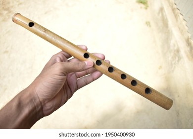 Flute in my hand :All of our handmade flutes are transverse flutes; this means that they are side blown flutes, played similar to a concert metal flute. - Shutterstock ID 1950400930