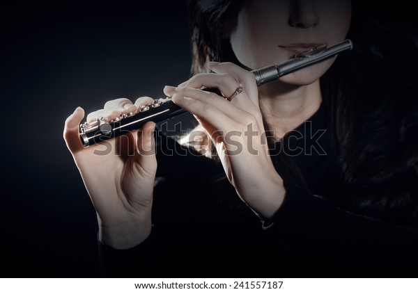 Flute piccolo Flutist playing music instrument\
flute player hands\
closeup