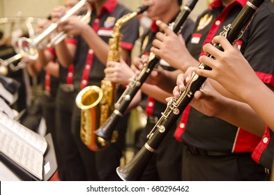 flute, trumpet and saxophones orchestra perform by high school boy