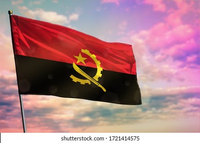 Fluttering Angola flag on colorful cloudy sky background. Angola prospering concept.