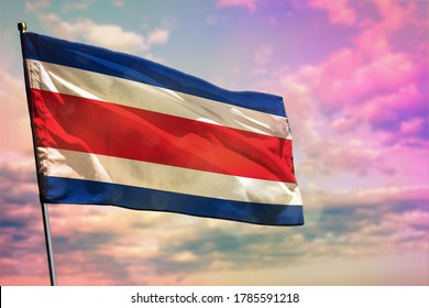 Fluttering Costa Rica flag on colorful cloudy sky background. Costa Rica prospering concept.