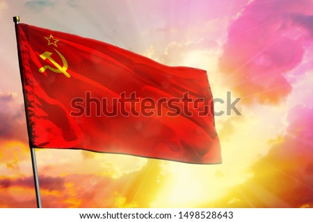 Fluttering Soviet Union (SSSR, USSR) flag on beautiful colorful sunset or sunrise background. Soviet Union (SSSR, USSR) success and happiness concept.