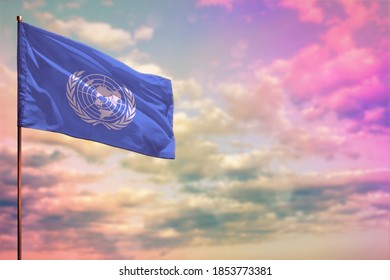 Fluttering United Nations flag mockup with the place for your text on colorful cloudy sky background.