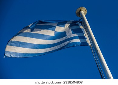 fluttering in the wind Flag of Greece on the ship floats in sea Greece flag waving against clean blue sky, close up, isolated