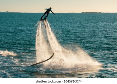 Fly Boarding Spinning Extreme Water Sports In Ras Al Khaimah, United Arab Emirates Near Dubai At Sunset Having Fun On The Water. Recreation And Sports Concepts.