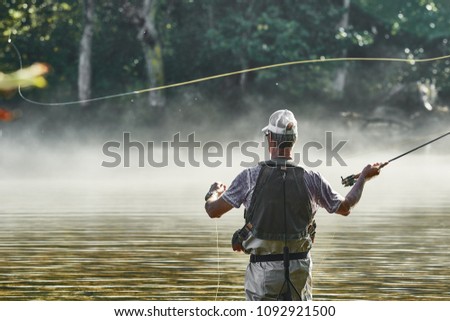 Fly Fisherman Casting Line While Wading In A Tennessee River