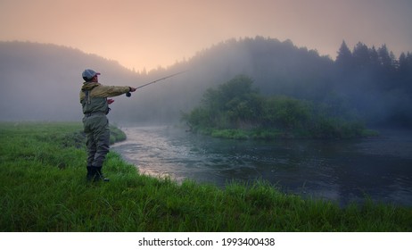 Fly fisherman fishing on the river at foggy sunrise - Powered by Shutterstock