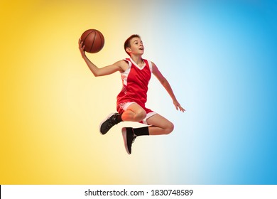In fly. Full length portrait of young basketball player in uniform on gradient studio background. Teenager confident posing with ball. Concept of sport, movement, healthy lifestyle, ad, action, motion