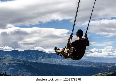 Fly. Man On Swing Kneeling In The Mountains. Freedom