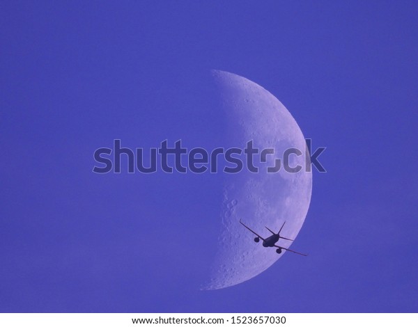 Fly me\
to the moon - airplane flying towards the\
moon