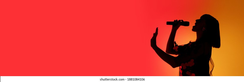 Flyer. Silhouette of young female singer isolated on orange gradient studio background in neon light. Beautiful shadow in action, performing. Concept of human emotions, expression, ad, music, art.